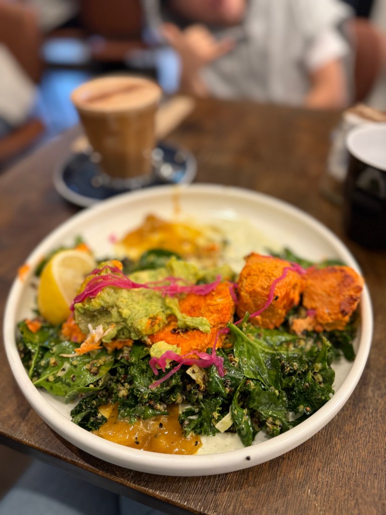 A plate of chicken tikka with kale salad, avocado and mango chutney.
